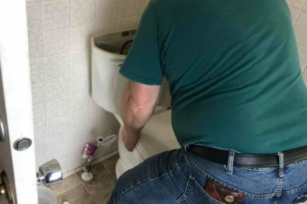 one person lifting the toilet