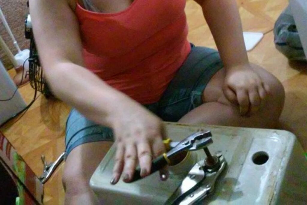 woman using wrenches to replace toilet tank bolts