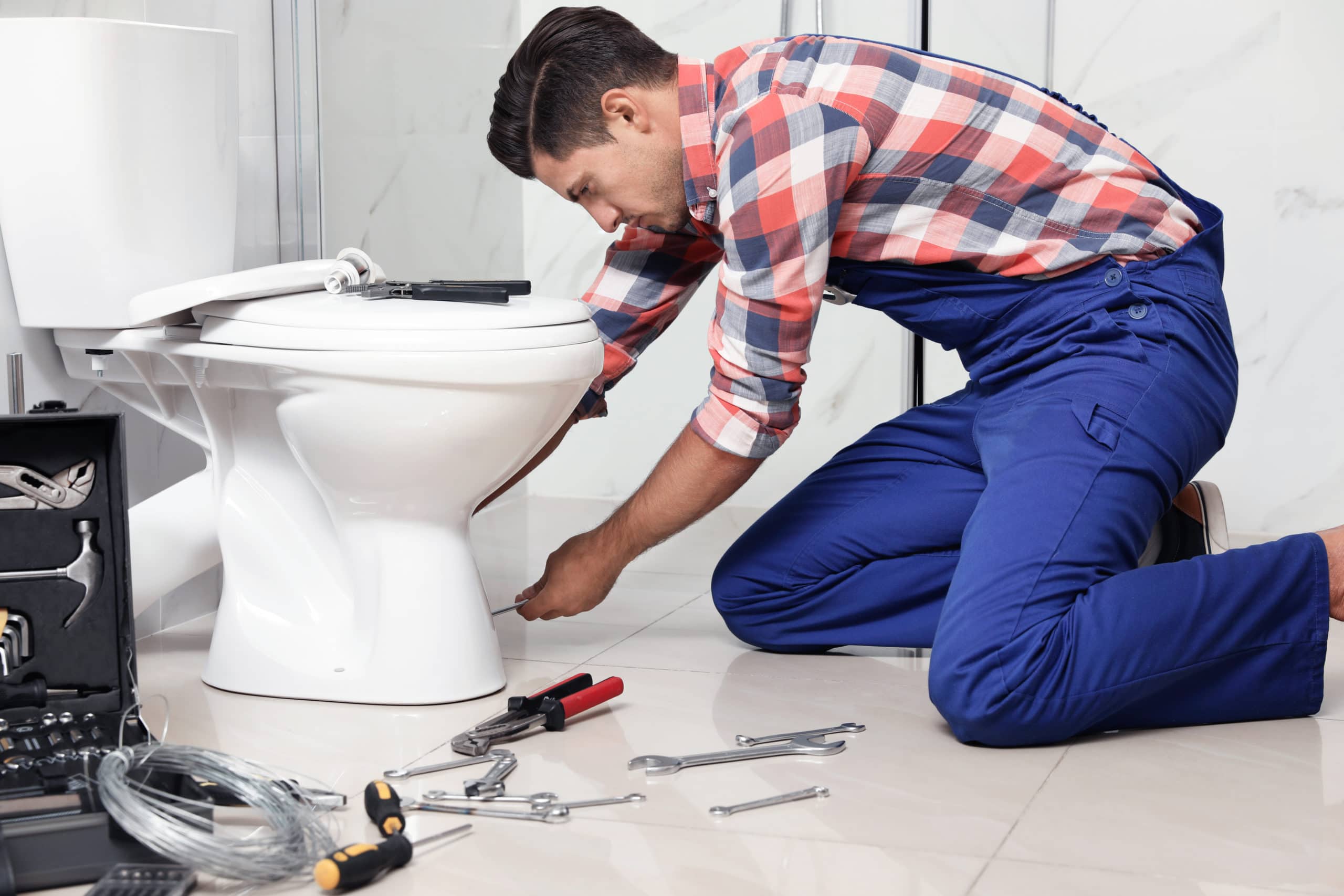 Professional plumber working with wobby toilet