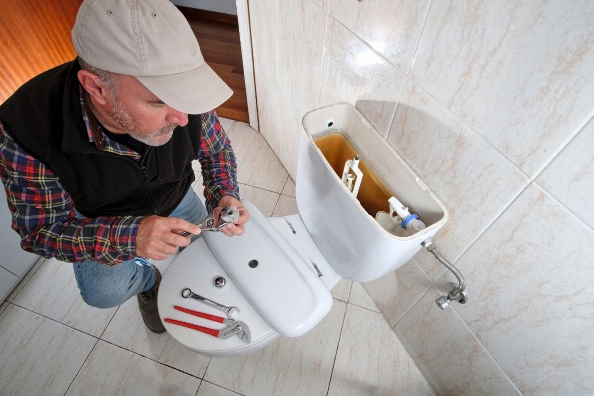 a man is fixing the toilet