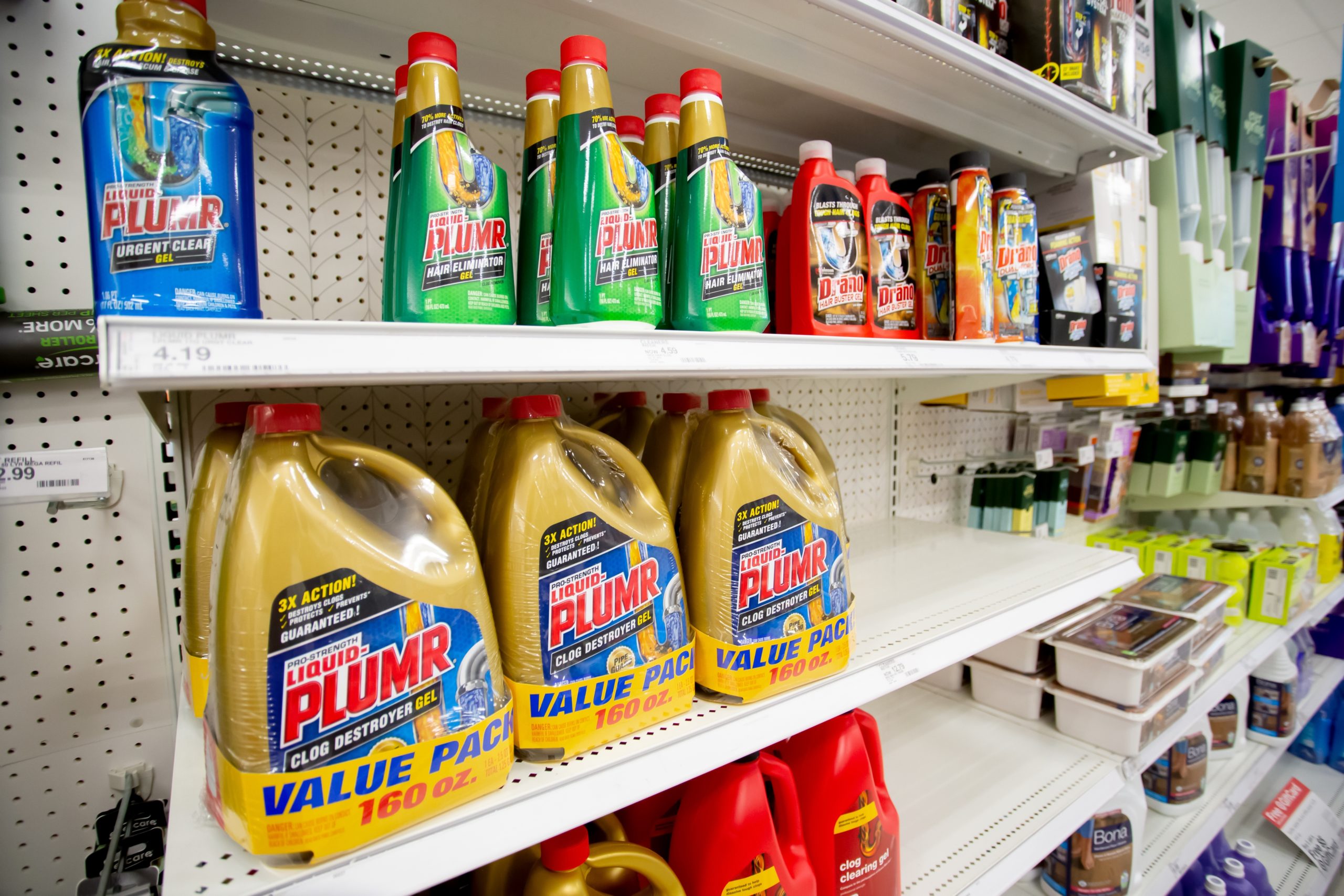 A view of several shelves dedicated to drain cleaning products like liquid plumber