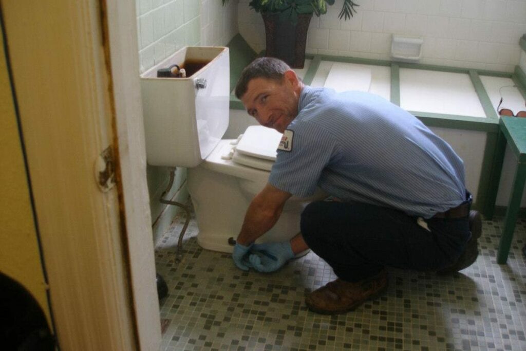 a plumber removing an old toilet
