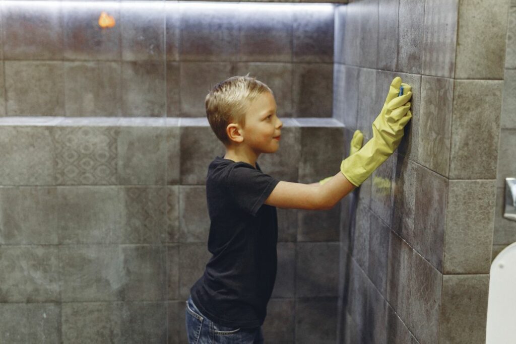 a boy cleaning a stone-walled Roman Shower