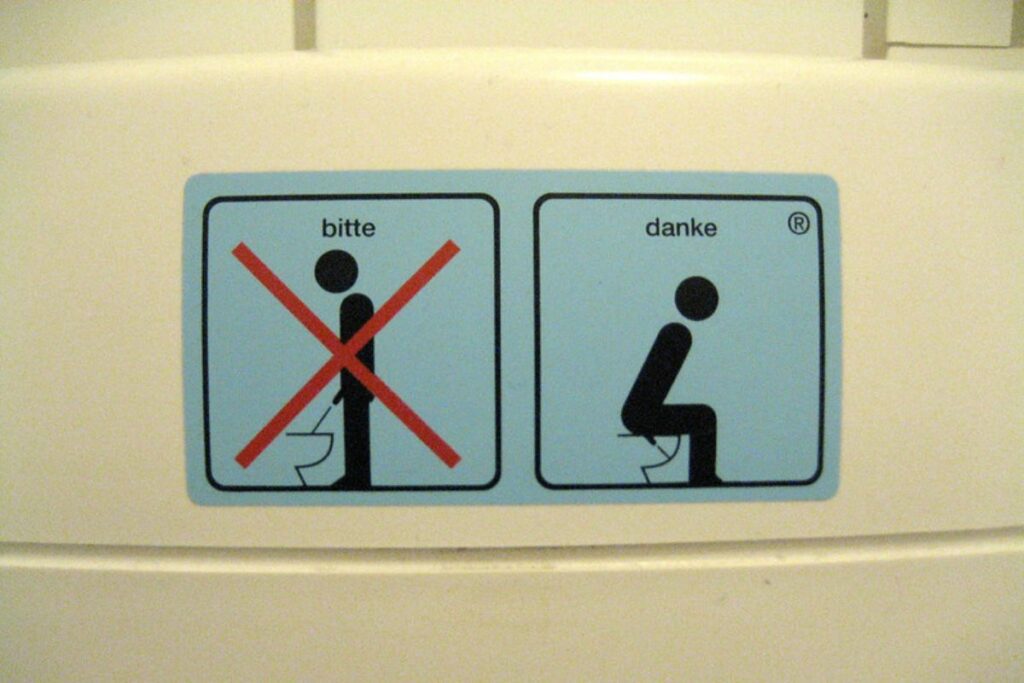 signage in some European countries that men should sit down to pee