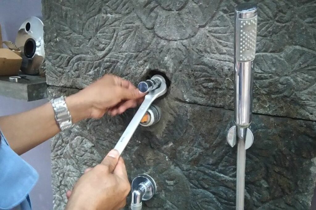 replacing a shower handle using a wrench