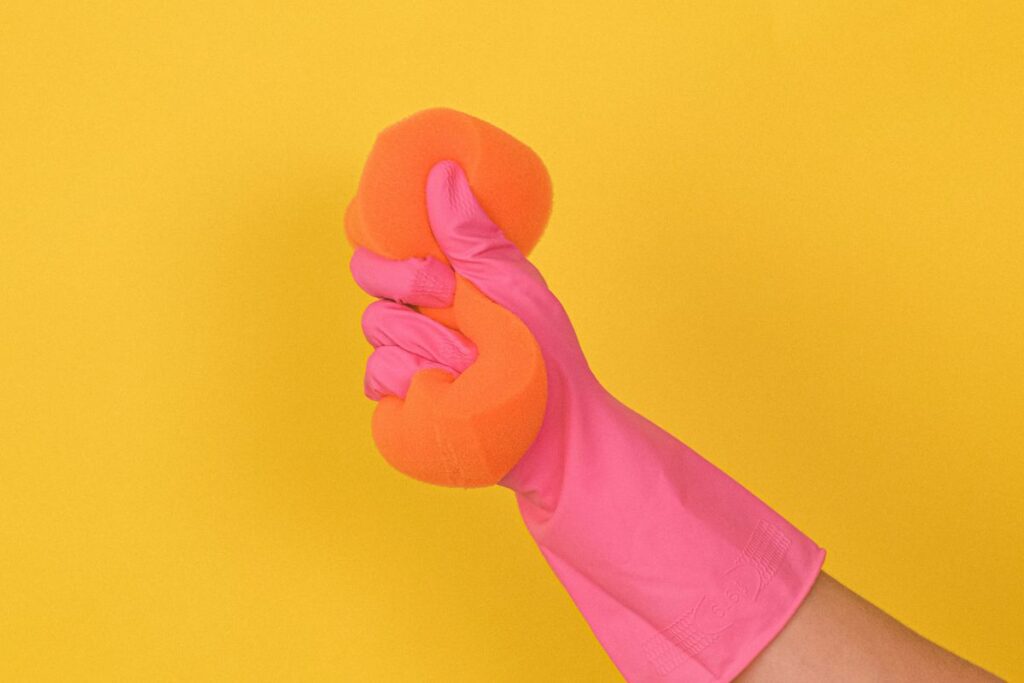 a person wearing a glove and holding a sponge