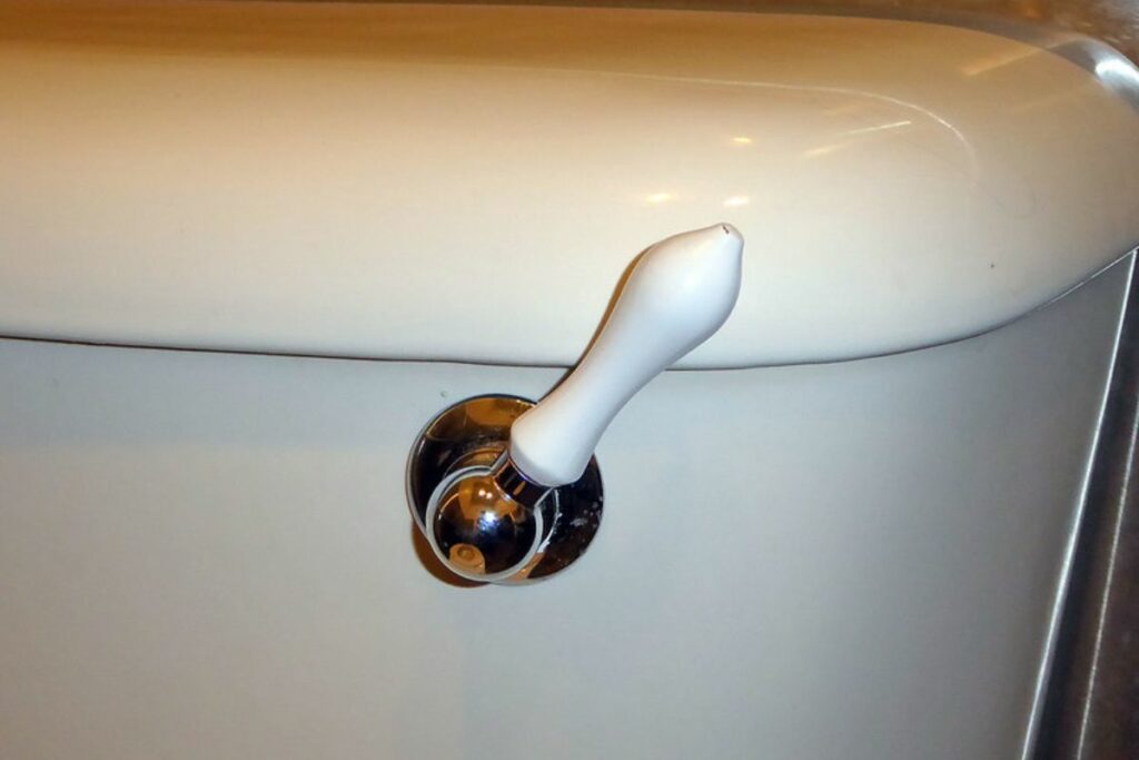 toilet flush handle located on the right side