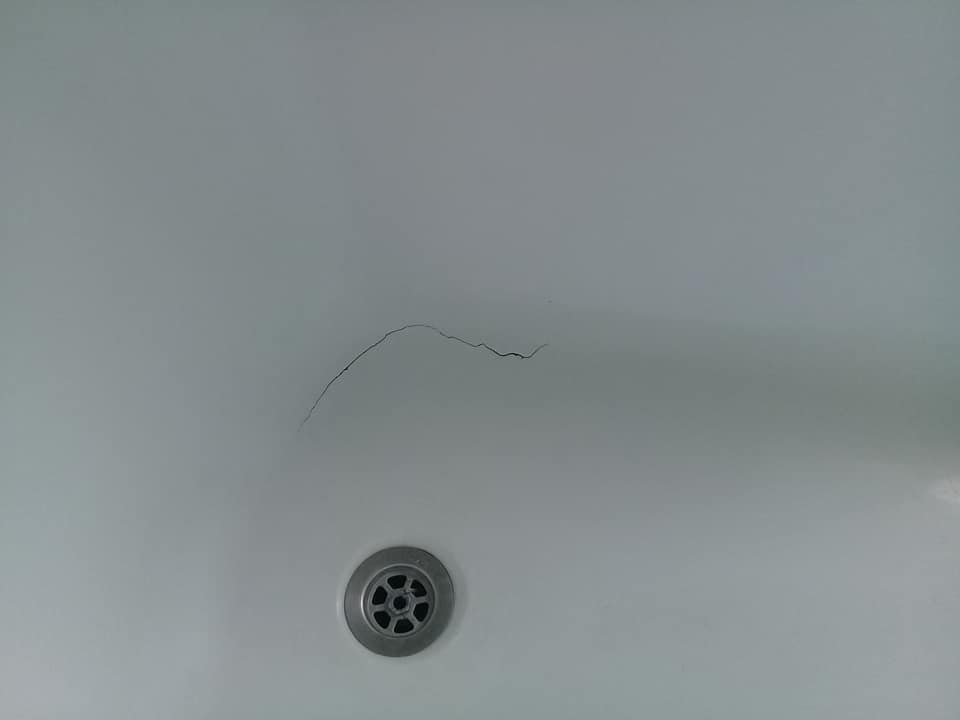 a close up photo of a fiberglass tub with thin hair crack