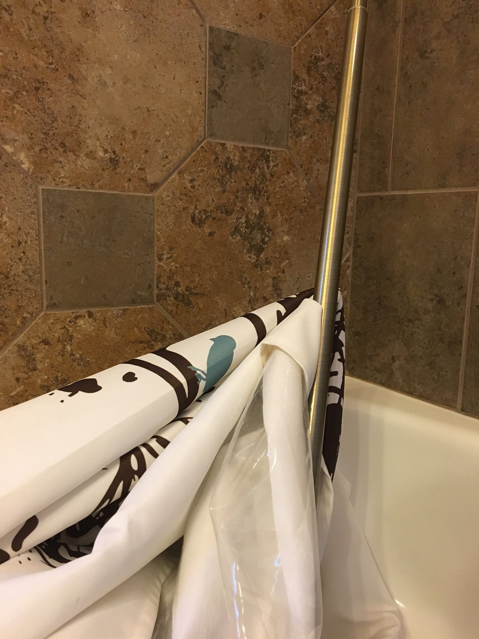 a shower curtain falling in the bathtub