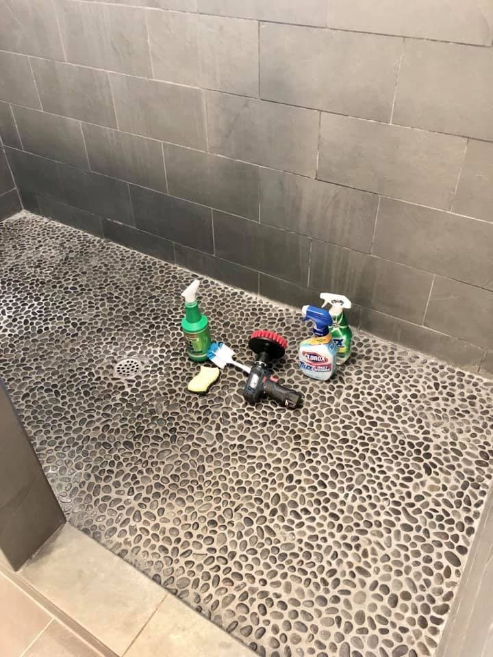 cleaning products on floor ready to clean the dirty slate shower