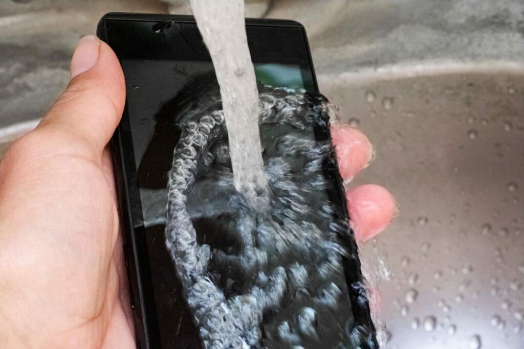 a waterproof phone being washed under water