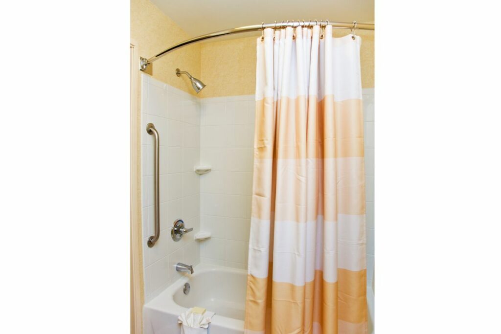 a bathroom with Curved Shower Rod and curtain