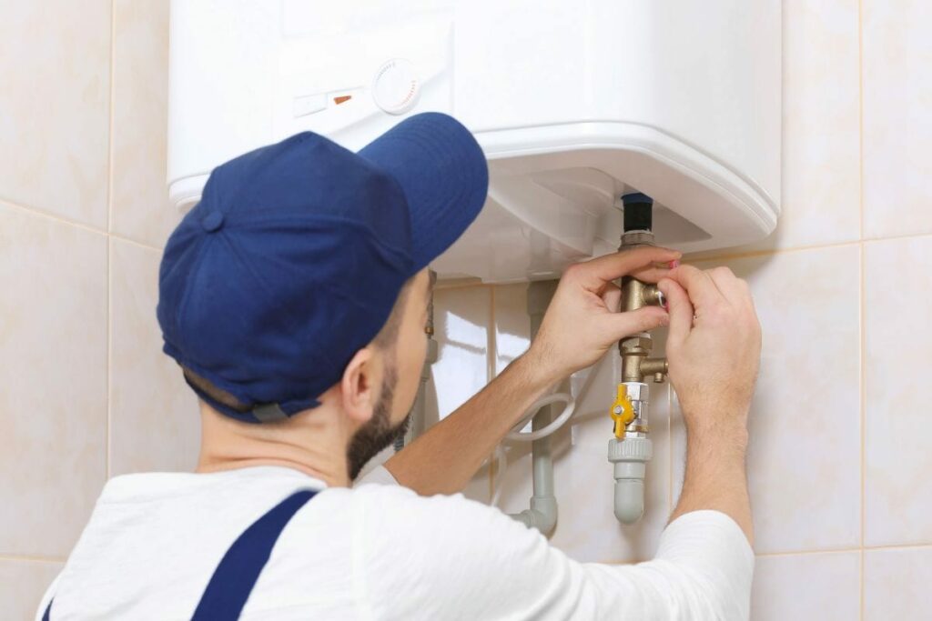 a handyman is adjusting a shower heater's mixing valve