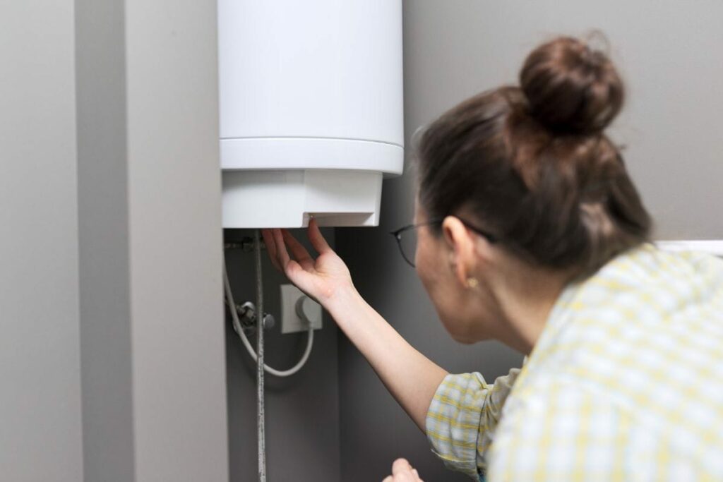 a woman is adjusting the water Temperature on a water heater