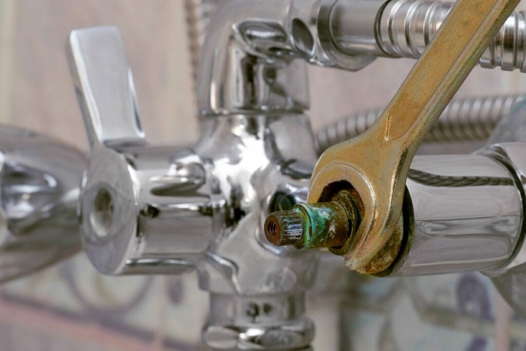 replacing defective ceramic disc cartridge covered with limescale in shower mixer using wrench